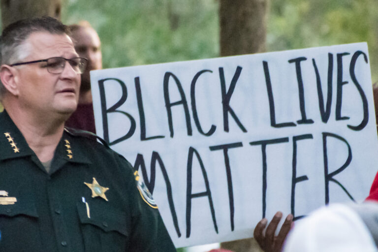 Sheriff Ivey in front of BLM sign.