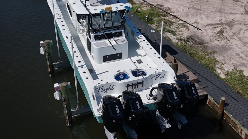 Drone photo of boat: "Light blue Freeman 42-foot center console boat named Flight Risk on lift at Brevard County property"